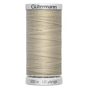 A spool of Gütermann polyester thread in a beige color. The spool label shows "100 m - 110 yds/vgs" indicating the length of the thread. The thread is neatly wound around the spool.