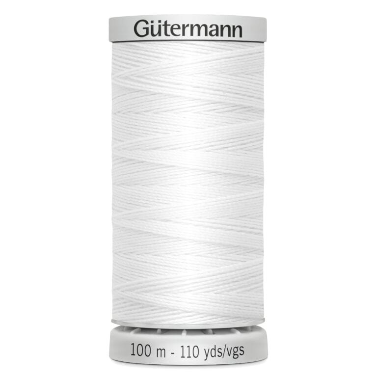 A spool of white Gütermann thread, labeled with "100 m - 110 yds/vgs," stands upright, showcasing its tightly wound texture.