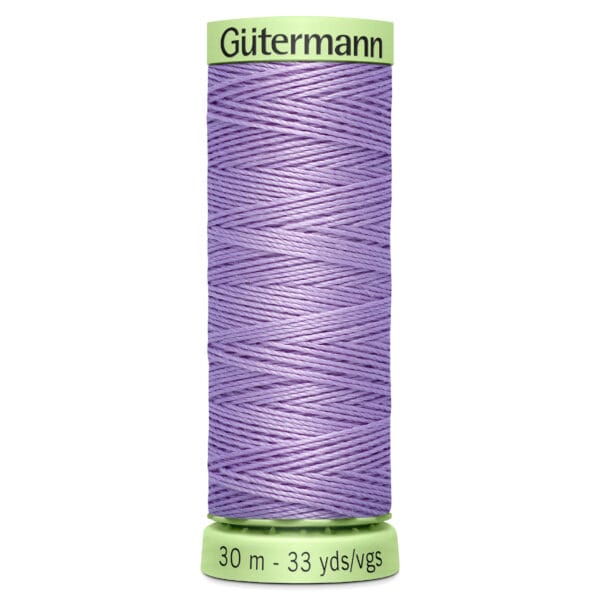 A spool of Gütermann thread in lavender, labeled with "30 m - 33 yds/vgs" at the bottom. The thread is tightly wound and displayed on a light green spool.