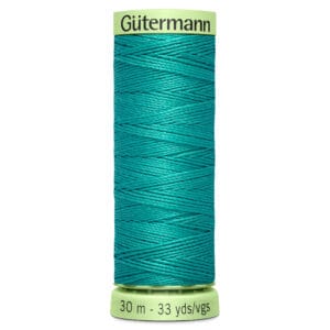 A spool of Gütermann sewing thread in a bright teal color, labeled with 30 meters (33 yards) on the bottom. The thread is neatly wound around the spool.