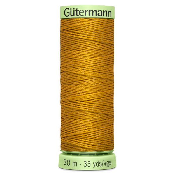 A spool of Gütermann sewing thread, golden yellow in color, wound tightly. The label indicates 30 meters or 33 yards. The spool is light green with black text.