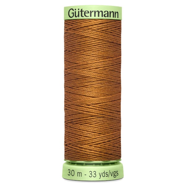 A spool of Gütermann brown thread on a light green base. The label indicates a length of 30 meters or 33 yards. The thread is neatly wound around the spool.