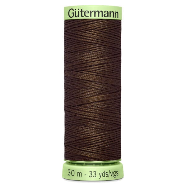 A spool of Gütermann brown thread, with a green label at the top and bottom. The label reads "30 m - 33 yds/vgs." The thread is neatly wound around the spool.