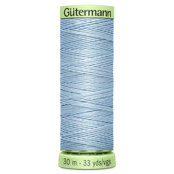 A spool of Güttermann sewing thread in light blue, labeled with measurements "30 m - 33 yds/vgs." The spool has a light green top and bottom.