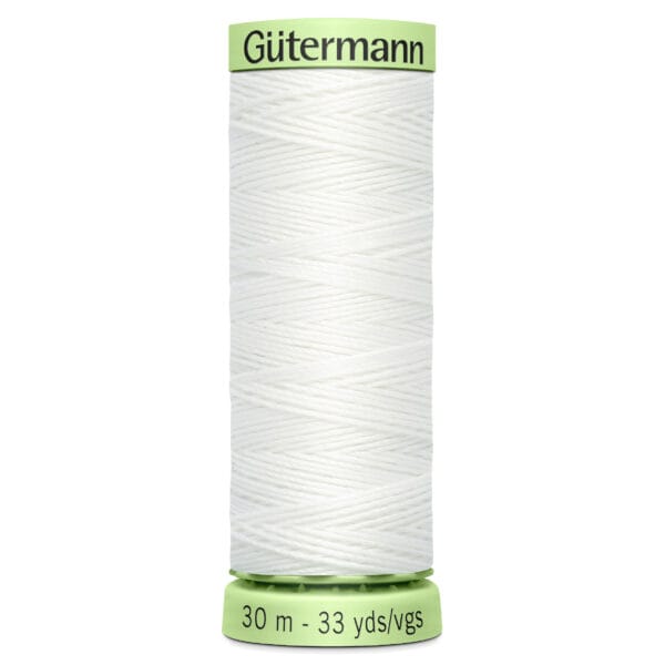 A green spool of Gütermann white sewing thread, labeled with "30 m - 33 yds/vgs" at the bottom. The thread is neatly wound around the spool.