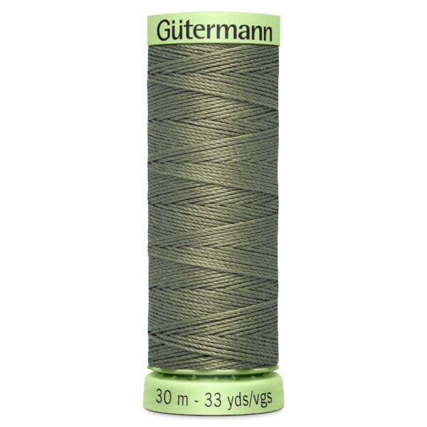 A spool of Gütermann sewing thread in olive green. The spool shows a neat, crisscrossed winding pattern. It is labeled with the length "30 m - 33 yds/vgs." The top and bottom of the spool are light green.