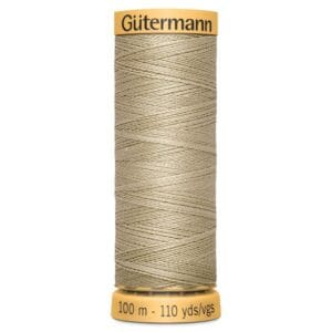 A spool of Gütermann beige sewing thread, labeled with "100 m - 110 yds/vgs" on the bottom and "Gütermann" on the top. The thread is tightly wound around the spool.