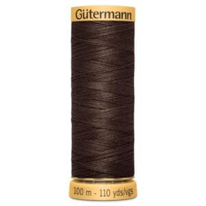 A spool of Gütermann brown sewing thread, 100 meters (110 yards), with the brand name on the top and length details on the bottom. The thread is tightly wound around the spool in a crisscross pattern.