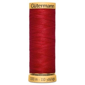 A spool of Gütermann thread in vibrant red with a yellow label on top. The label reads "Gütermann." The spool indicates 100 meters or 110 yards of thread. The thread is neatly wound around a cylindrical core.