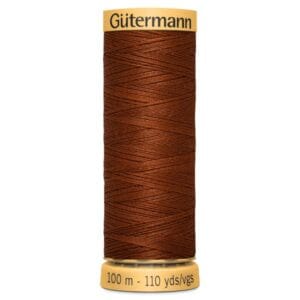 A spool of Gütermann thread in a rich brown color. The label indicates it is 100 meters or 110 yards long. The spool has a beige top and bottom with the brand name and thread length printed on it.