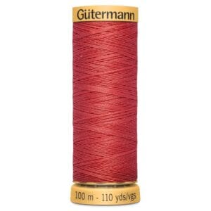 A spool of Gütermann thread in red. The label indicates it contains 100 meters (110 yards) of thread. The spool is upright against a white background, showing the thread's texture and vibrant color.