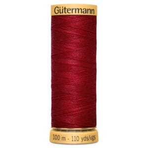 A spool of Gütermann thread in deep red color. The spool is labeled with a yellow cap and base, indicating 100 meters and 110 yards in length.