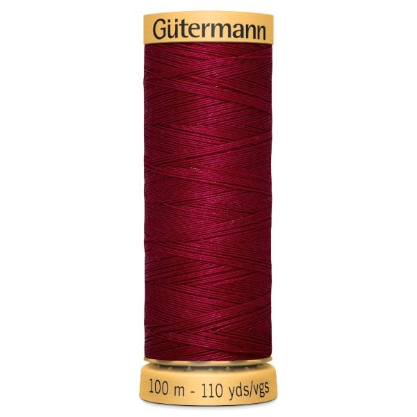 Spool of deep red Gütermann sewing thread on a matching yellow base. The text on the label reads "Gütermann" at the top and "100 m - 110 yds/vgs" at the bottom.