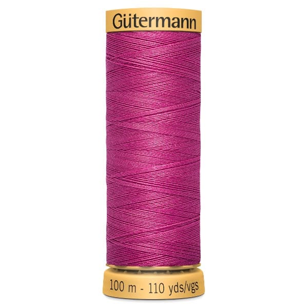 A spool of Gütermann sewing thread in vibrant magenta. The spool features a yellow label with the brand name and length indicators: 100 meters and 110 yards.