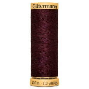 A spool of Gütermann thread in deep burgundy color. The label on the top shows the brand name, and the base indicates the length as 100 meters (110 yards).
