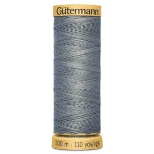 A spool of Gütermann thread, labeled "100 m - 110 yds," with gray thread. The top and bottom edges of the spool are yellow.