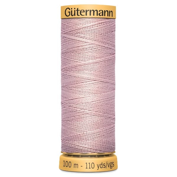 A spool of Gutermann sewing thread in light pink, labeled with a yellow top and base indicating 100 meters or 110 yards of thread. The thread is neatly wound in a crisscross pattern around the spool.