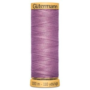 A spool of Gütermann sewing thread in a light purple color, wrapped neatly around the spool. The label indicates a length of 100 meters or 110 yards.