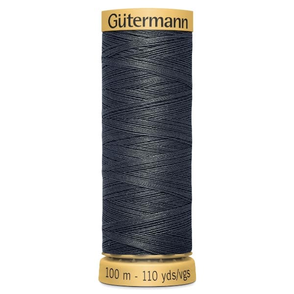 A spool of Gütermann thread, black in color, with a yellow label. It measures 100 meters or 110 yards. The thread is tightly wound, and the brand name is printed on the top of the spool.