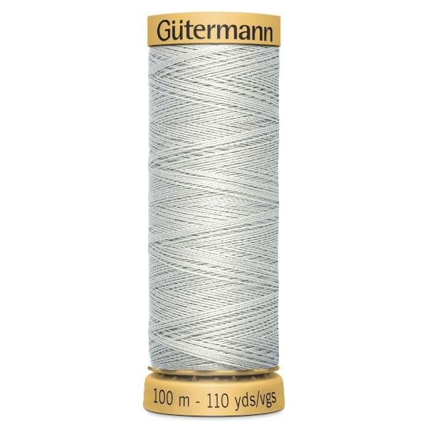 Spool of Gütermann sewing thread, light grey in color, with a label indicating 100 meters or 110 yards of thread. The spool is cylindrical with a tan top and bottom.