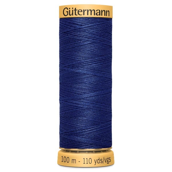 A spool of Gütermann sewing thread in deep blue, with a label indicating 100 meters/110 yards. The spool has a yellow plastic top and bottom, with the brand name visible on the top.