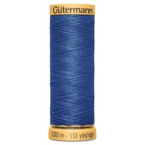 A spool of Gütermann thread shows tightly wound blue thread. The label indicates 100 meters or 110 yards. The spool is cylindrical with yellow ends, and the thread is neatly arranged in a crisscross pattern.