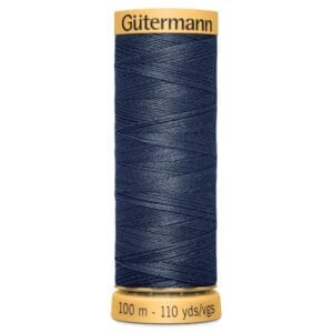 A spool of Gütermann thread, colored in dark blue, with labels indicating its length as 100 meters or 110 yards. The spool has yellow ends with the brand name written on top.