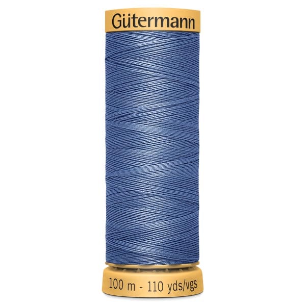 A spool of Gütermann thread, 100 meters or 110 yards, in a shade of blue. The spool is cylindrical with a yellow top and bottom, labeled with the brand name and length.