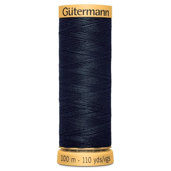 A spool of Gütermann sewing thread, navy blue in color, with a yellow label. The spool indicates 100 meters or 110 yards of thread. The thread is tightly wound in a crisscross pattern.