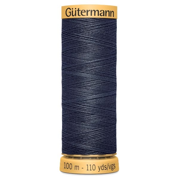 A spool of Gütermann thread in dark blue, labeled with "100 m - 110 yds/vgs." The spool has a yellow top and bottom, with the brand name "Gütermann" on the top.