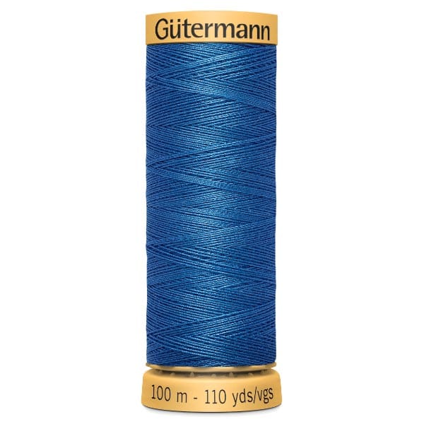 A spool of Gütermann blue sewing thread, labeled with "100 m - 110 yds/vgs" at the bottom and "Gütermann" at the top. The thread is tightly wound around the spool.