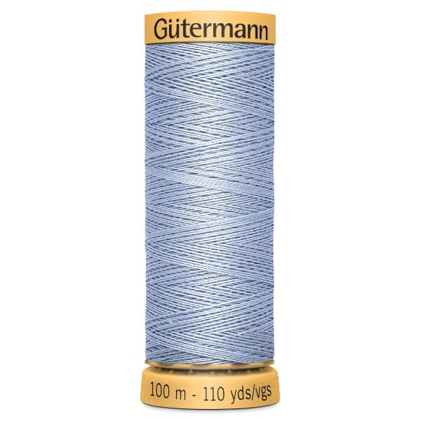 Spool of Gütermann light blue sewing thread labeled "100 m - 110 yds/vgs". The thread is neatly wound on a yellow spool with the brand name on top.