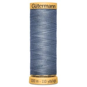 A spool of Gütermann blue sewing thread with a yellow label. The spool holds 100 meters or 110 yards of thread, as indicated at the bottom.