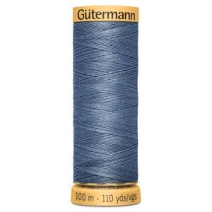 Spool of Gütermann sewing thread in denim blue, holding 100 meters (110 yards). The thread is wound neatly around a yellow spool with product information printed on it.
