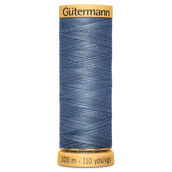 Spool of Gütermann sewing thread in denim blue, holding 100 meters (110 yards). The thread is wound neatly around a yellow spool with product information printed on it.