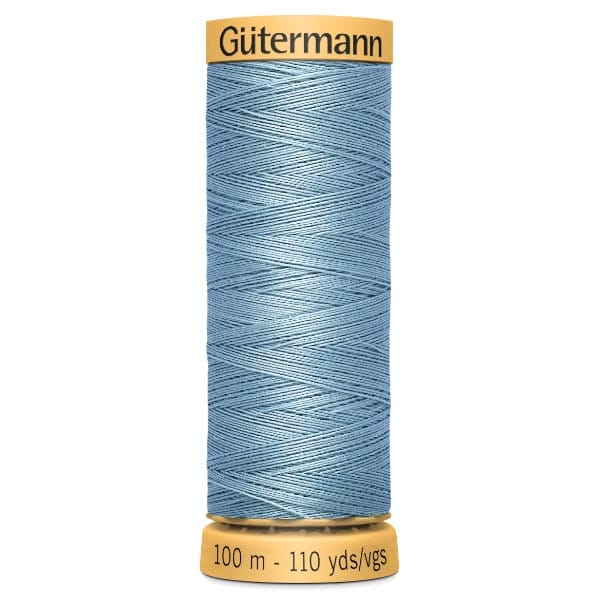 A spool of Gütermann sewing thread in light blue, with a capacity of 100 meters or 110 yards. The top and bottom of the spool are yellow with black text indicating the brand and length.