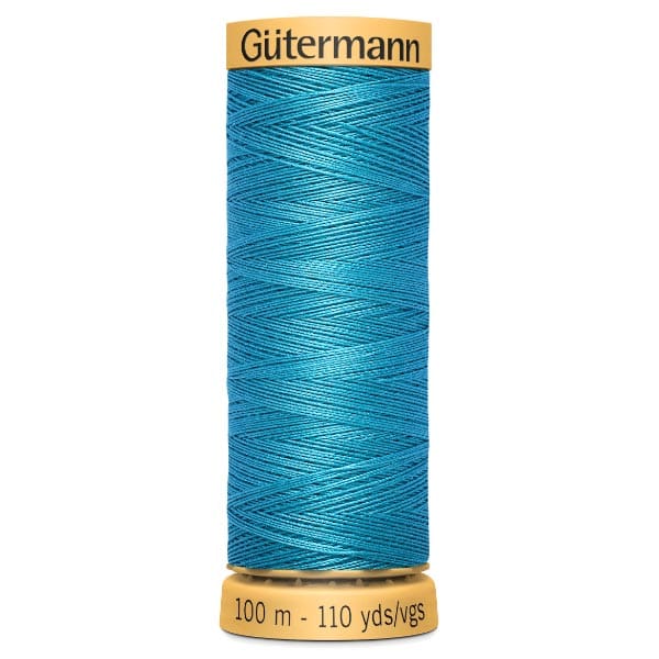 A spool of Gütermann thread in bright turquoise, showing a tightly wound cylindrical shape. The label on the top displays the brand name, and the bottom label indicates a length of 100 meters or 110 yards.