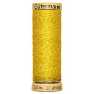 A spool of yellow Gütermann sewing thread, labeled with "100 m - 110 yds/vgs." The thread is tightly wound, and the spool is cylindrical with beige ends displaying the brand name.