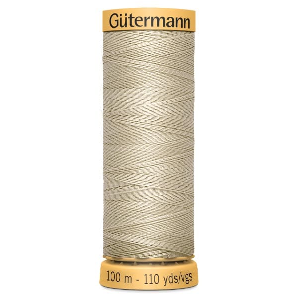 A spool of beige Gütermann thread, labeled with "100 m - 110 yds/vgs" on the base. The spool has a yellow top and bottom with the brand name on the top.