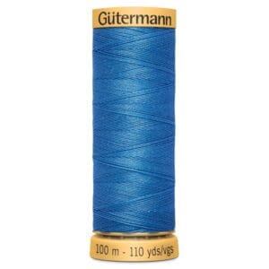 A spool of Gütermann blue sewing thread. The label at the top displays the brand name, and the bottom shows measurements: 100 meters and 110 yards. The thread is neatly wound in a crisscross pattern.