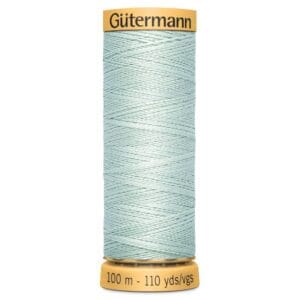 A spool of Gutermann sewing thread in light blue. The spool is labeled with measurements: 100 meters and 110 yards. The thread is neatly wound on the spool, and the label is yellow with black text.