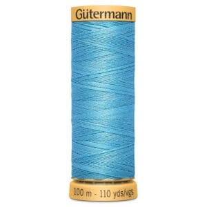 A spool of Gütermann sewing thread in bright blue, with a label showing "100 m - 110 yds/vgs." The spool has yellow ends with the brand name printed on the top.