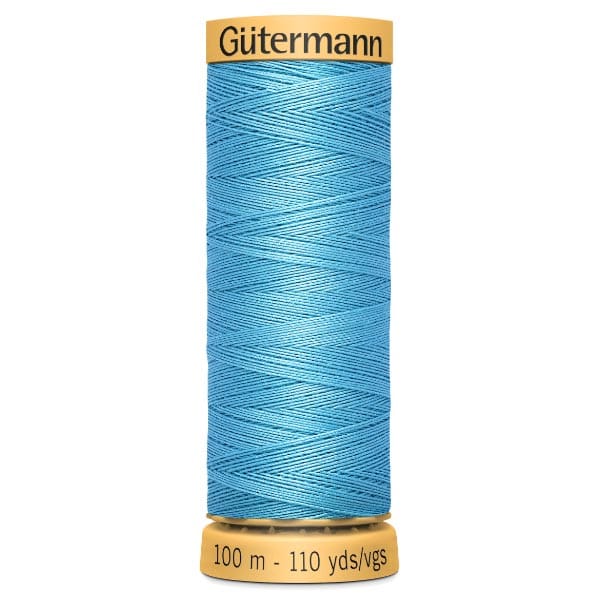 A spool of Gütermann sewing thread in bright blue, with a label showing "100 m - 110 yds/vgs." The spool has yellow ends with the brand name printed on the top.