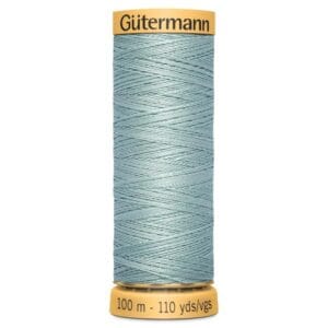 A spool of Gütermann sewing thread in a light blue color, labeled for 100 meters or 110 yards. The spool has a yellow cap and base.