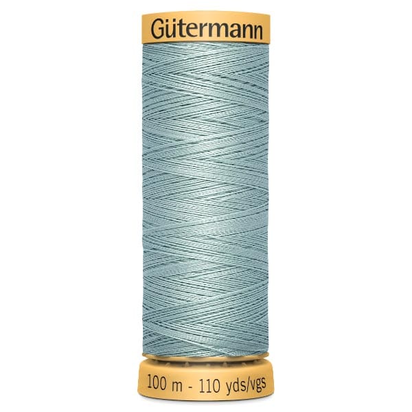 A spool of Gütermann sewing thread in a light blue color, labeled for 100 meters or 110 yards. The spool has a yellow cap and base.