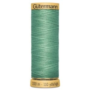 A spool of Gütermann green sewing thread, measuring 100 meters or 110 yards, on a yellow base. The thread is wound neatly in a crisscross pattern.