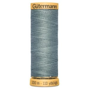 A spool of Gütermann sewing thread in a muted teal color, wrapped evenly around a spool. The top and bottom of the spool display the brand name and the length of the thread, which is 100 meters or 110 yards.