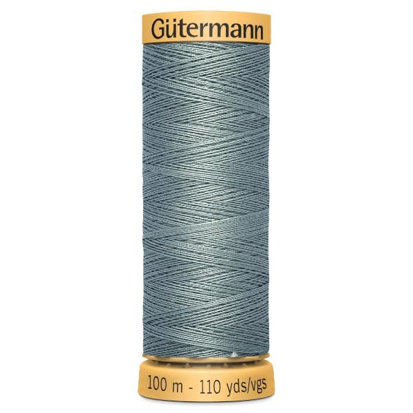 A spool of Gütermann sewing thread in a muted teal color, wrapped evenly around a spool. The top and bottom of the spool display the brand name and the length of the thread, which is 100 meters or 110 yards.