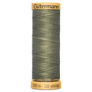 A spool of Gütermann sewing thread in a muted green color. The label indicates it contains 100 meters or 110 yards of thread. The thread is neatly wound around the spool.