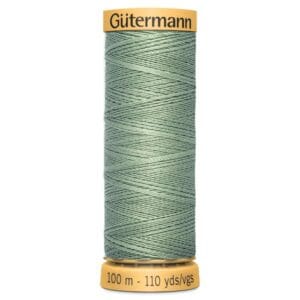 A spool of Gütermann sewing thread in a light sage green color. The label indicates it is 100 meters or 110 yards long. The spool has a yellow cap and base.